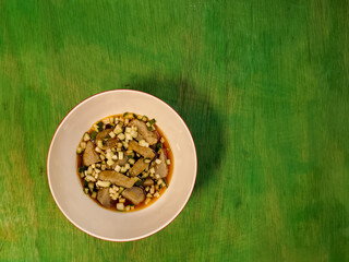 a bowl of empek-empek food on a green table