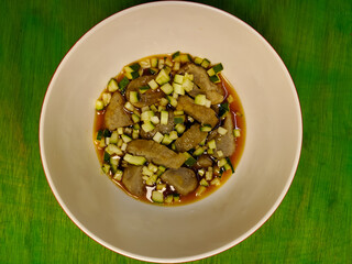 a bowl of empek-empek food on a green table