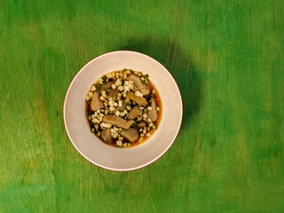 a bowl of empek-empek food on a green table