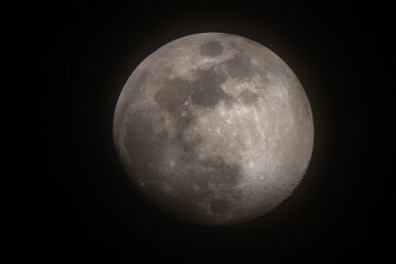 Nearly full moon shining at night with visible lunar details