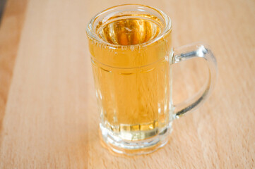 beer in a small glass, wooden background,