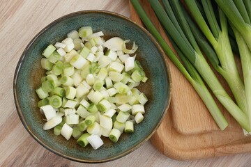 Fresh green onions on a chopping board and in a bowl. Homegrown organic green onions full of vitamins.