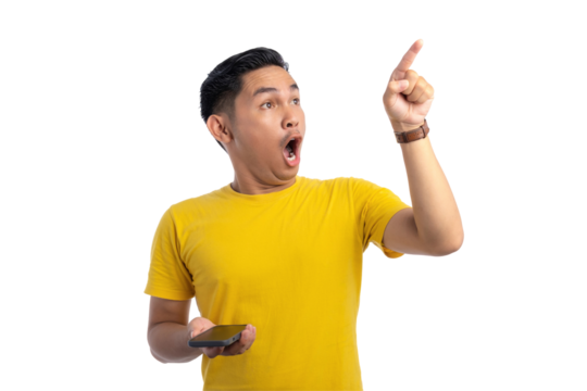 Shocked young Asian man holding mobile phone and pointing finger in the air with amazed expression isolated on transparent background