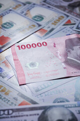 background of piles of US dollar banknotes overlapping Indonesian rupiah banknotes. illustration of inflation of the US dollar currency against the Indonesian rupiah currency