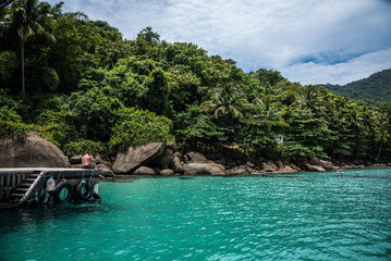 Man on Pier Overlooking Turquoise Waters in Angra dos Reis, Brazil