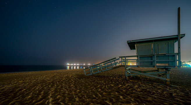 Hermosa Beach at night with lifeguard tower and illuminated pier 