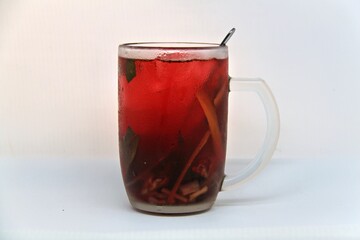 Chilled version of Wedang Uwuh, a traditional Indonesian herbal drink made with ginger, cinnamon, cloves, and lemongrass. Served cold with a vibrant red color and refreshing taste.