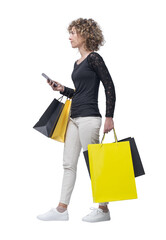 Smiling woman walking and holding shopping bags