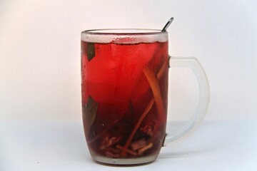 Chilled version of Wedang Uwuh, a traditional Indonesian herbal drink made with ginger, cinnamon, cloves, and lemongrass. Served cold with a vibrant red color and refreshing taste.