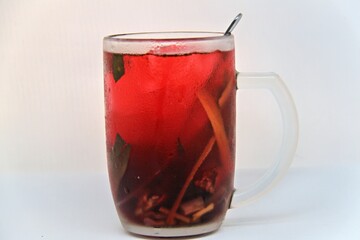 Chilled version of Wedang Uwuh, a traditional Indonesian herbal drink made with ginger, cinnamon, cloves, and lemongrass. Served cold with a vibrant red color and refreshing taste.