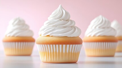 Freshly baked vanilla cupcakes with swirled white frosting on a light pink background, and close-up composition highlighting texture and detail.