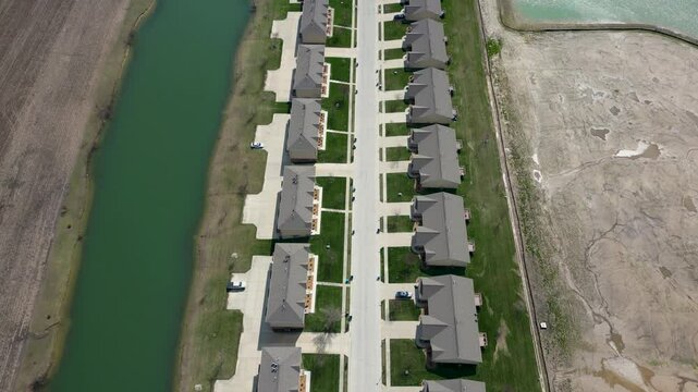 A new suburban street built between undeveloped farmland. The orderly suburban streen creates an interesting juxtoposition with the surroundings.