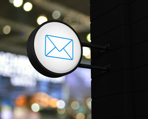 email icon on hanging black rounded signboard over blur light and shadow of shopping mall, Business contact us online concept, 3D rendering
