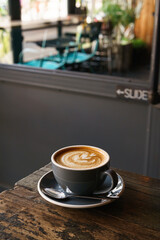 Hot coffee latte with latte art milk foam in cup mug on wood desk on top view. As breakfast In a coffee shop at the cafe,during business work concept,vintage style