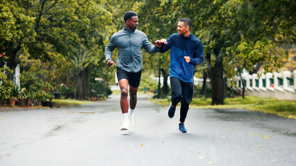 Fitness, running and people with fist bump outdoor for marathon training, challenge success and race celebration. Friends, team building and runner club with workout progress, sports support and jog
