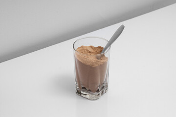 Cocoa powder and cinnamon in a bowl with a glass of cocoa powder creating a delicious sweet dessert scene