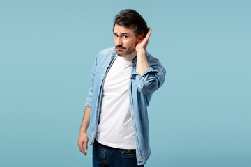 Curious man overhearing conversation holding hand near ear trying to listen carefully