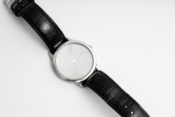 Silver wristwatch with leather band isolated on black and white backgrounds, showcasing time and luxury