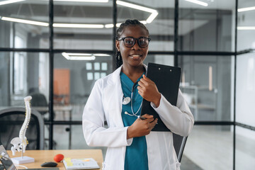 In white coat. Female doctor in coat is in the office clinic