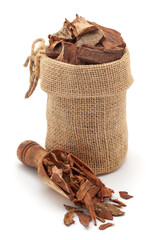 Close-up of Dry Organic Arjuna Barks (Terminalia Arjuna), in a jute bag and on a scoop, Isolated on a white background.