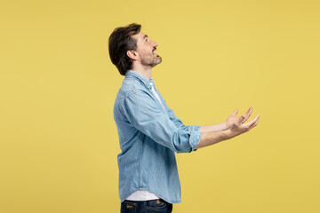 Man showing or receiving something with open hands on yellow background