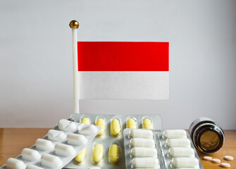 Flag of Indonesia with Pills and Capsules. Pharmaceutical Concept
