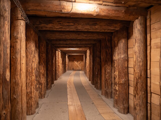 Obraz premium A wooden tunnel deep inside the Wieliczka Salt Mine in Poland, showcasing traditional timber construction techniques used to support underground passages.