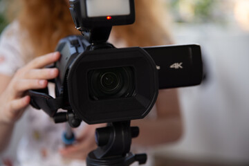 zemka on a video camera, video camera redhead girl shoots video with a professional video camera,...