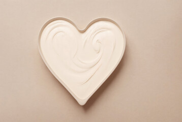 White cosmetic cream in heart-shaped packaging, top view. Cosmetic product for facial skin care