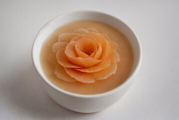 Apricot jam in ceramic white bowl on gray background. Top view
