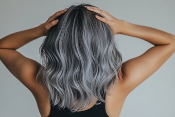 Fototapeta premium a woman with shoulder-length wavy gray hair, viewed from behind.