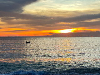 sunset on the beach with boats