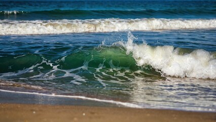 Fototapeta premium Blue ocean waves crash on the sandy beach shore under the summer sky