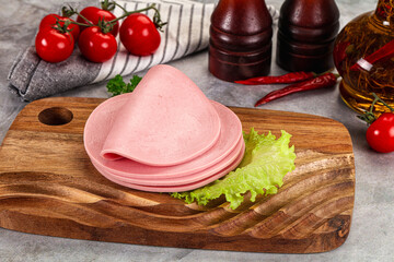 Sliced boiled sausage over board