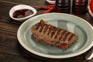 Grilled beef striploin steak with sauce
