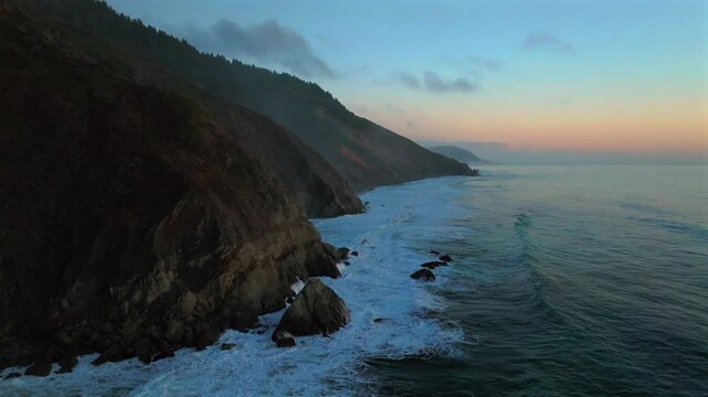 California ocean nature scene USAL Beach Campground aerial drone bluffs cliffside mist clouds mountain rocky rugged remote coast vibrant sunset Sinkyone Wilderness waves crashing surf swell backwards