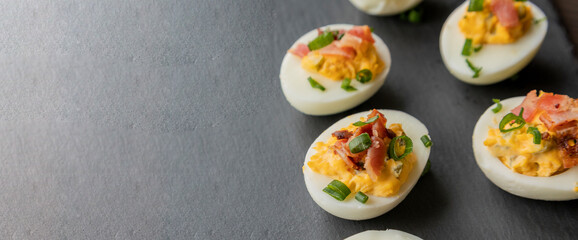  party appetizer featuring deviled eggs topped with crispy bacon and chopped green onions