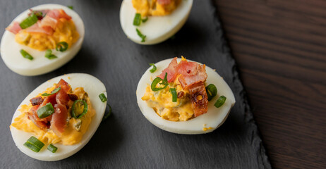  party appetizer featuring deviled eggs topped with crispy bacon and chopped green onions