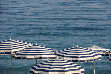 Beach umbrellas against the backdrop of the turquoise sea. Summer vacations and holidays. Copy space.