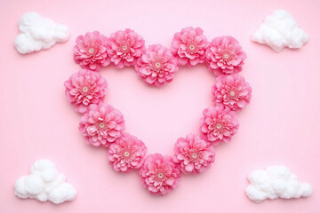 heart shaped arrangement of pink flowers in the sky