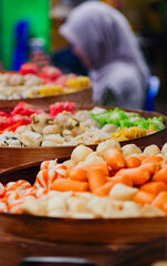 Colorful steamed dim sum, Various kinds of sushi for sale in market, Selective of focus, typical Japanese food, tempura and sushi in wooden boxes