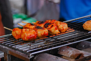 Corndog fried dry on bamboo skewers, served with a spread of sauce, cheap street food, crispy and tasty