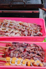 Seafood, raw squid before grilling placed on a white tray, Barbeque Grill Street Food Meat, vegetables and Chinese sausage.
