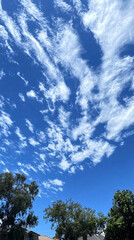 Obraz premium Radiant Skies: A Bright Sun Shining Over Fluffy White Clouds Against a Clear Blue Background