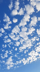 Radiant Skies: A Bright Sun Shining Over Fluffy White Clouds Against a Clear Blue Background
