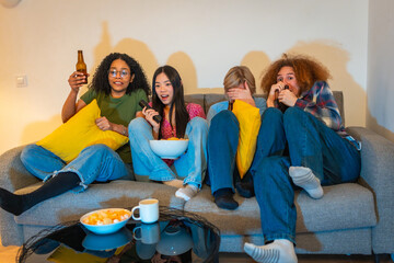 Friends watching scary movie on tv with snacks and drinks
