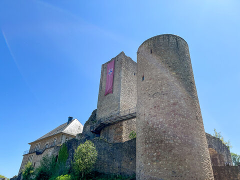 Useldange Castle with medieval banner hanging from the tower. Luxembourg.