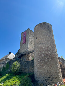 Useldange Castle with medieval banner hanging from the tower. Luxembourg.