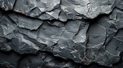 Dark gray slate rock texture with layered, fractured surface.
