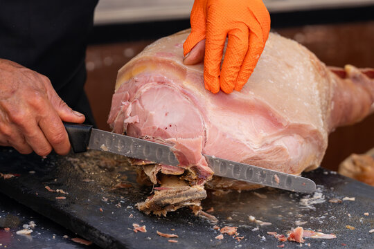 Close-up of a cook cutting the traditional Galician pork shoulder, typical of Spanish gastronomy